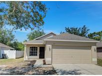 Charming single-Gathering home featuring a two-car garage, neutral paint scheme, and a well-maintained lawn at 923 Brenton Leaf Dr, Ruskin, FL 33570
