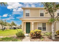 Charming two-story home featuring a well-kept lawn, a green front door, and colorful landscaping at 4722 67Th N Ave, Pinellas Park, FL 33781