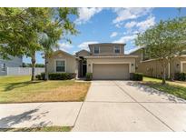 Charming home featuring a two-car garage, well-manicured lawn, and inviting curb appeal at 13188 Royal Pines Ave, Riverview, FL 33579