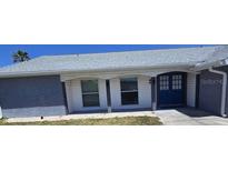 Charming single-story home featuring a blue front door and neutral brick and siding at 3309 Rock Valley Dr, Holiday, FL 34691
