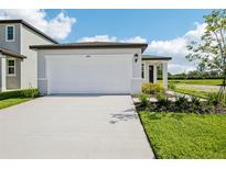 New home featuring a two car garage, and newly installed landscaping at 14118 Crutchfield Ct, Parrish, FL 34219
