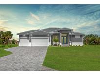 Beautiful new construction home with a three car garage, paver driveway, lush lawn and modern design at 193 Rotonda S Blvd, Rotonda West, FL 33947