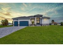 Beautiful single-story home featuring a spacious lawn and a two-car garage at 211 Rotonda S Blvd, Rotonda West, FL 33947