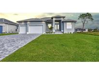 Beautiful gray home with well manicured lawn and paver driveway, offering great curb appeal at 221 Rotonda S Blvd, Rotonda West, FL 33947