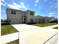 Two-story home with a two-car garage, well-manicured lawn, and a long concrete driveway at 17826 Canopy Pl, Bradenton, FL 34211
