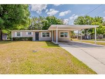 Charming single-story home featuring a covered carport and well-maintained front yard at 4906 S 87Th St, Tampa, FL 33619