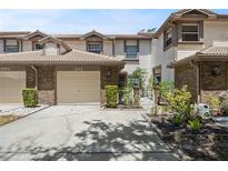 Charming townhouse with a well-maintained front yard, featuring a brick facade and an attached garage for convenient parking at 1171 Clays Trl, Oldsmar, FL 34677