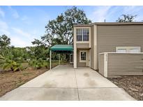 Charming two-story home with a covered parking area and landscaped surroundings at 6902 Lakeview Ct, Tampa, FL 33634
