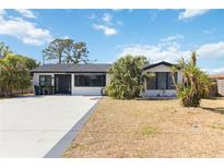 Charming single-story home featuring a well-maintained lawn and a freshly painted exterior at 75 Virginia Ct, Englewood, FL 34223