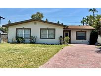 Charming single-story home featuring a well-maintained lawn and a welcoming brick pathway at 3735 Alabama Ne Ave, St Petersburg, FL 33703