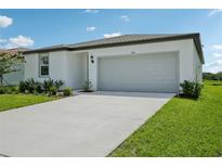 Charming single-story home with a well-maintained lawn, a two-car garage, and lush landscaping at 7740 Gilchrist Springs Dr, Parrish, FL 34219