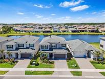 Aerial view of lakeside community featuring manicured lawns, and stylish two-story homes at 3061 Hollow Hickory Pl, Wesley Chapel, FL 33543
