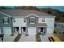 Modern townhouses with neutral exteriors, individual garages and manicured landscaping create curb appeal at 1570 Hubbell Rd, Wesley Chapel, FL 33543