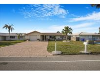 Charming single-story home with a brick driveway, a well-maintained lawn, and a cozy, inviting curb appeal at 4043 Topsail Trl, New Port Richey, FL 34652