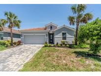 Charming single-story home with a red tile roof and tropical landscaping at 507 Daylily Blvd, Nokomis, FL 34275