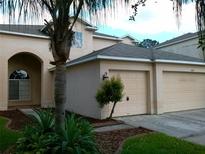 Charming two-story home with a well-maintained front yard and a two car garage at 2011 N 61St St, Tampa, FL 33619