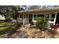 Charming single-story home featuring a cozy front porch and lush tropical landscaping at 3141 Irving St, Sarasota, FL 34237