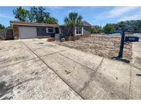 Charming single-story home featuring a gray exterior, well-maintained lawn, and a concrete driveway at 8253 Penwood Dr, Port Richey, FL 34668
