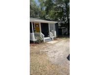 Charming home with a cozy front porch, painted steps, and a bright yellow front door at 5004 E Seneca Ave, Tampa, FL 33617