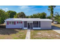 Charming single-story home featuring a screened entryway and a well-maintained front yard at 22131 Bahama Ave, Port Charlotte, FL 33952