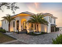 Elegant home featuring a well-manicured lawn, palm trees, and stylish pavers leading to the grand entrance at 3310 Sunset N Dr, St Petersburg, FL 33710