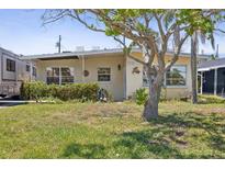 Charming single-story home featuring a well-maintained lawn and mature landscaping, creating a welcoming curb appeal at 15406 2Nd E St, Madeira Beach, FL 33708