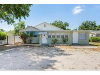 Charming single-story home featuring light green siding, a bright white front door, and well-maintained landscaping at 4100 46Th N Ave, St Petersburg, FL 33714