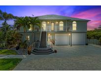 Charming two-story home with a well-maintained driveway, stairs to the front door, and tropical landscaping at 24145 Blackbeard Blvd, Punta Gorda, FL 33955