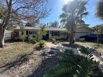 Charming home featuring a well-manicured front yard with brick pathway and mature landscaping at 560 7Th S St, Safety Harbor, FL 34695