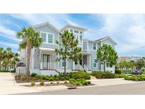 Charming two-story home featuring light blue siding, manicured landscaping, and a welcoming front porch and a palm tree at 283 Saint Lucia Dr # 202, Bradenton, FL 34209