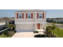 Charming two-story home with neutral siding, red shutters, a welcoming front door, and a well-maintained lawn at 6438 Milestone Loop, Palmetto, FL 34221