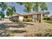 Charming home with a well-maintained front yard and mature landscaping, including a small fountain and decorative shrubbery at 7418 Riverbank Dr, New Port Richey, FL 34655