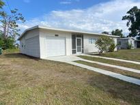 Charming single-story home with a screened entry, garage, and well-maintained front yard at 22011 Catherine Ave, Port Charlotte, FL 33952