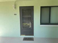 View of a front door with a 'welcome' mat and a window to the right at 129 Caryl Way # 129, Oldsmar, FL 34677