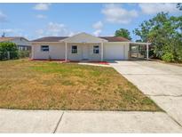 Charming single-story home features a quaint front porch, attached garage, and driveway at 38832 Henry Dr, Zephyrhills, FL 33542