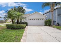 Charming home featuring a two-car garage, well-manicured landscaping, and a welcoming front entrance at 3319 Thistledown Ln, Land O Lakes, FL 34638