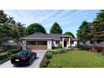 Stunning one-story home featuring a well-manicured front yard and a dark colored car parked in front at 16491 Hillsborough Blvd, Port Charlotte, FL 33954