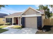 Charming single-Gathering home featuring a stone accented garage and a well-manicured front lawn at 1904 Crown Park Dr, Valrico, FL 33594