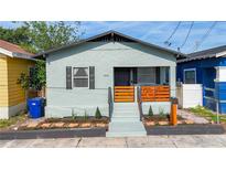 Charming single-story home featuring a cozy front porch with a wooden railing and fresh landscaping at 2904 Sanchez St, Tampa, FL 33605