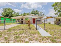 Charming single-story home featuring a red door, covered parking, and a fenced yard at 4812 N 37Th St, Tampa, FL 33610