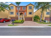 Inviting townhome featuring a well-manicured yard and brick paved driveway, perfect for comfortable living at 1408 3Rd Street E Cir, Palmetto, FL 34221