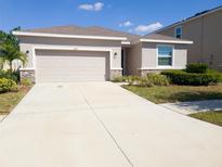Charming single-story home with a two-car garage and a well-manicured lawn, perfect for families at 5144 Flowing Oar Rd, Wimauma, FL 33598