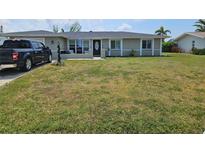 Charming single-story home featuring a well-maintained lawn and inviting front porch at 119 Caddy Rd, Rotonda West, FL 33947