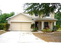 Traditional two-story home featuring an attached two car garage and a covered front porch at 11511 Misty Isle Ln, Riverview, FL 33579