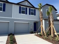 Charming exterior elevation of a two-story townhome with blue shutters and landscaping at 32122 Eastern Redbud Br, San Antonio, FL 33576