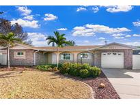 Charming home featuring a stone facade, well-manicured landscaping, and a quaint, inviting front yard at 5511 1St Avenue Nw Dr, Bradenton, FL 34209