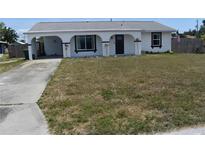 Charming home with an arched porch, black trim, and a drought resistant front yard at 821 Silver Springs Nw Ter, Port Charlotte, FL 33948