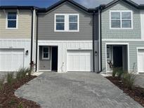 Charming townhomes featuring multi-tone exterior and modern paver driveway for inviting curb appeal at 7677 Deer Valley Circle, Tampa, FL 33635