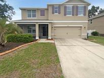 Charming two-story home with a two-car garage and well-manicured landscaping in a Gathering-friendly neighborhood at 5383 Magdalene Way, Zephyrhills, FL 33541