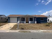 Charming single-story home featuring a front yard, a garage, and a welcoming entrance at 3347 Roxbury Dr, Holiday, FL 34691